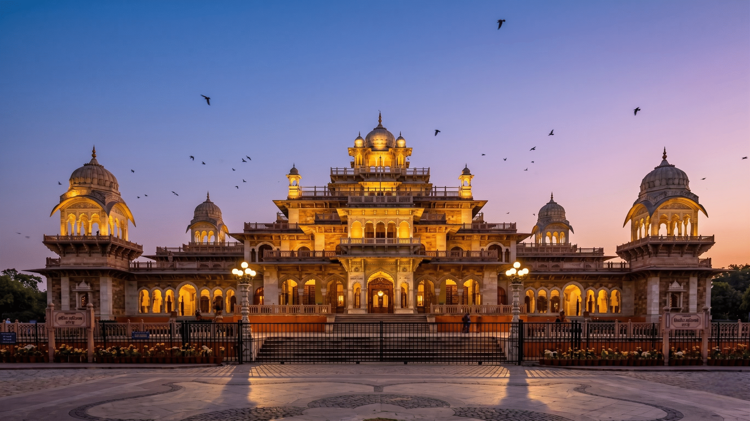 The illuminated Indo-Saracenic architecture of the historic Albert Hall Museum building during the evening in Jaipur.